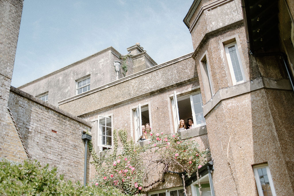 Wedding party looking out from the windows of Ripple Court Estate